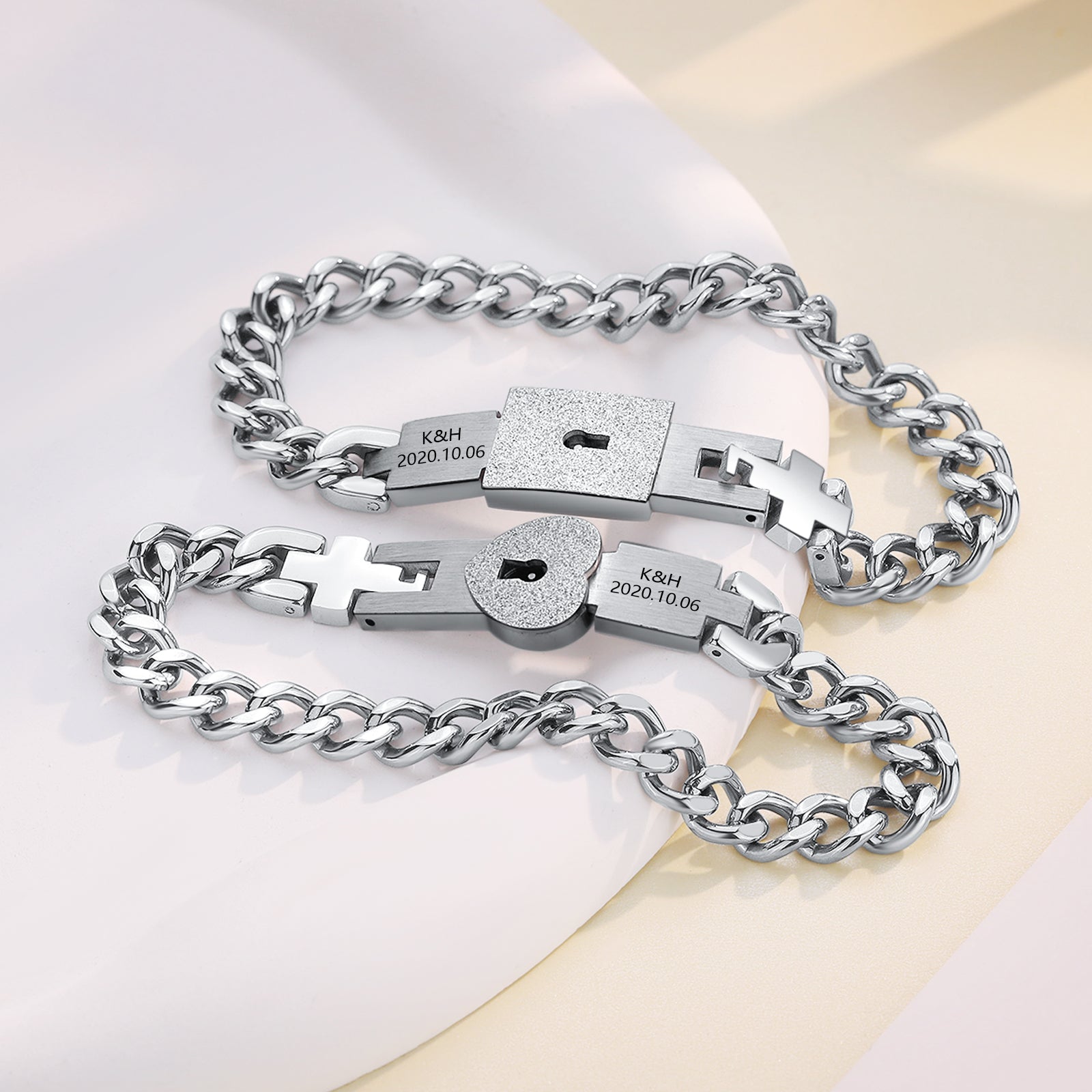 Silver couple bracelet with birthday keychain charm on white background.