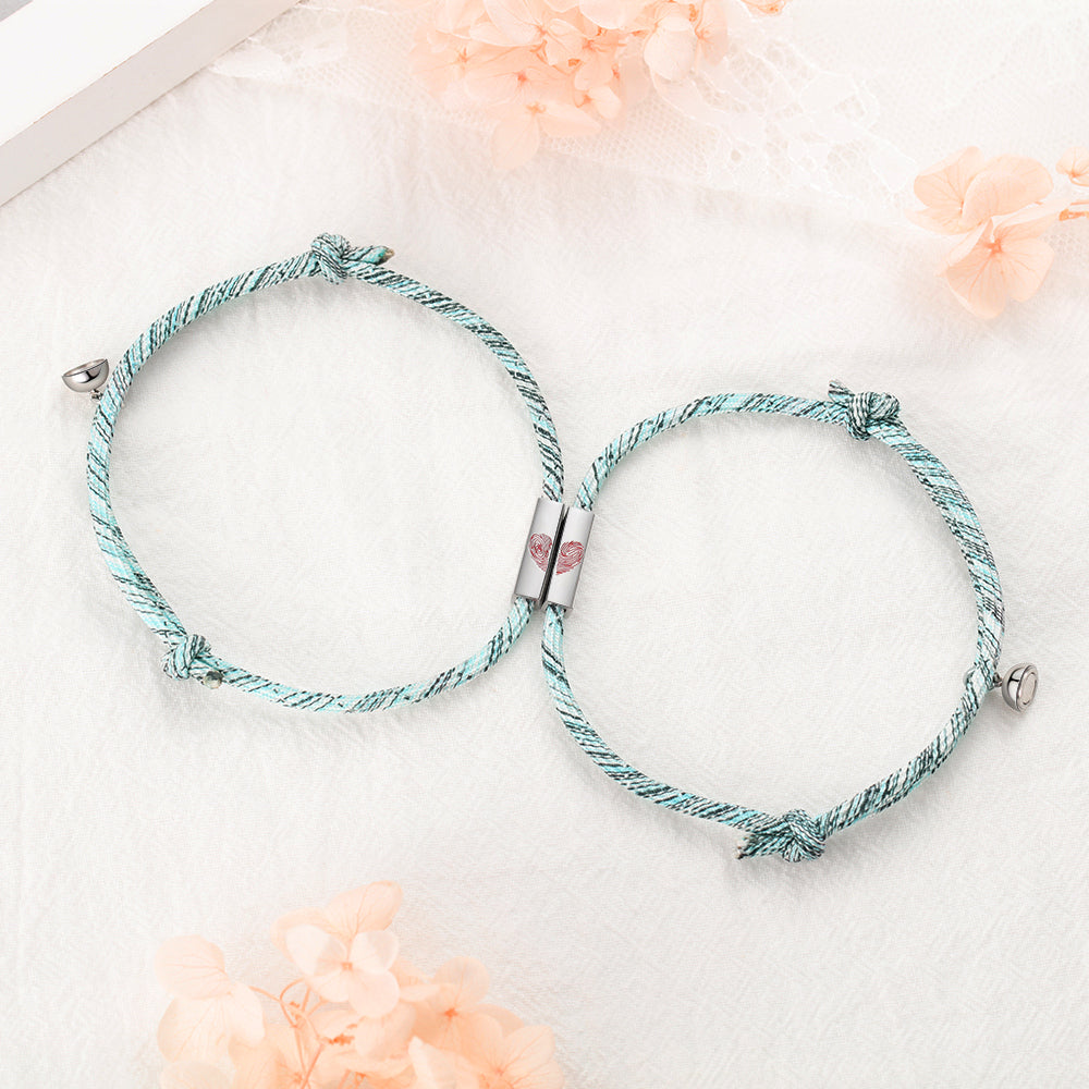 family keychain, Couple Bracelet with silver bell and heart, nestled among pink flowers and feather.