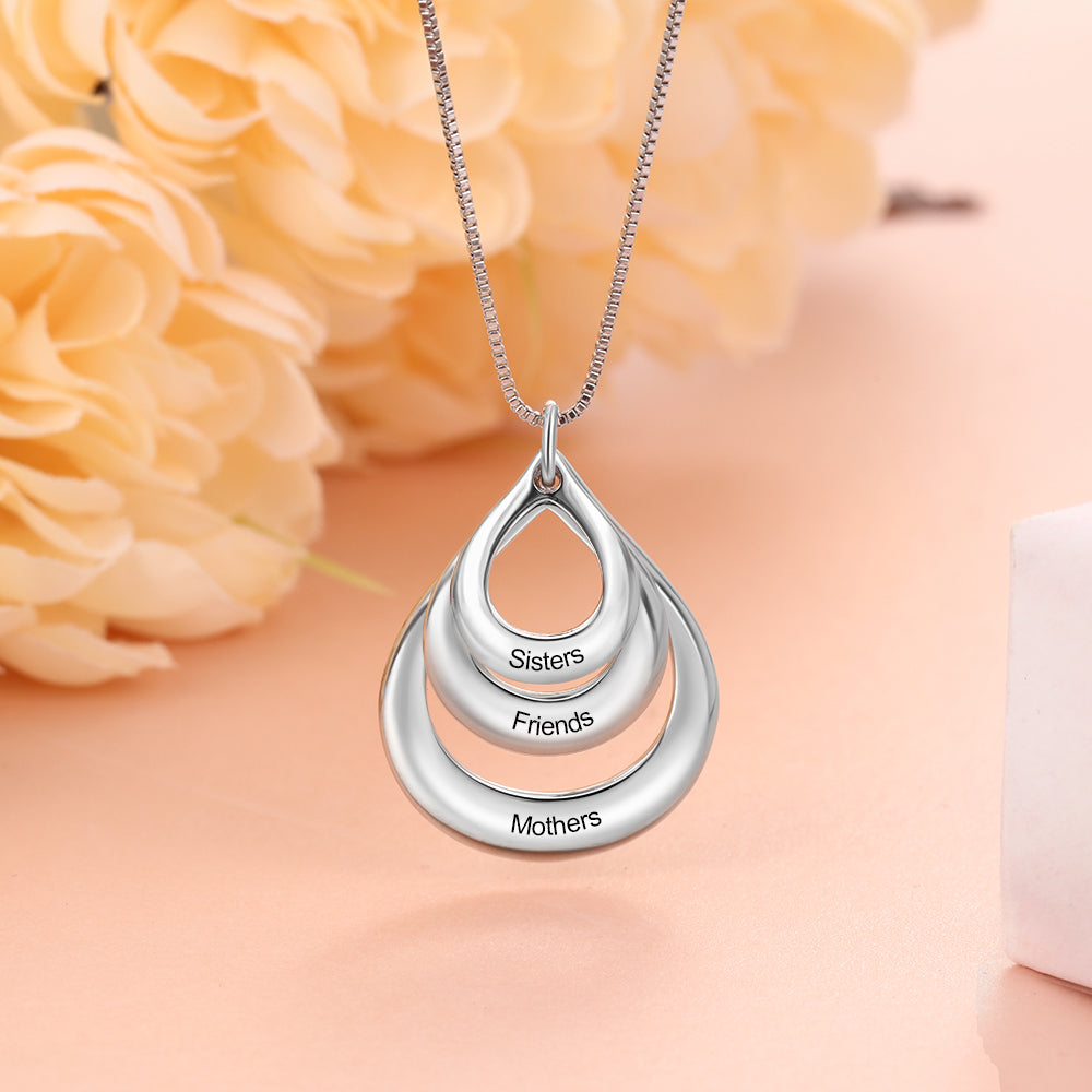 Custom Circle Necklace personalized with "Sisters," "Friends," "Mothers" on pink backdrop.