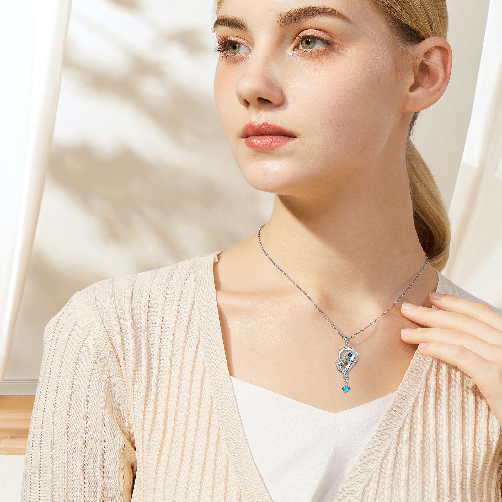 ring sound, Young woman in beige cardigan with personalized jewelry, heart pendant necklace.