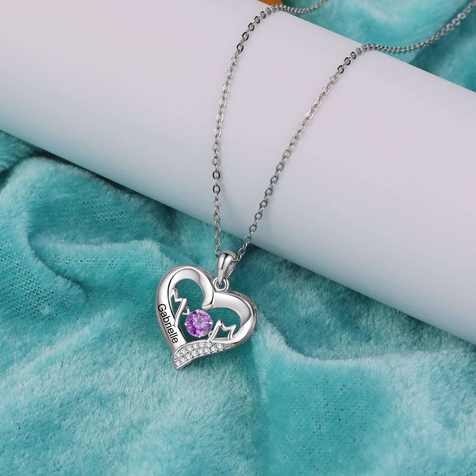 anniversary necklace, Silver heart pendant necklace with a purple gemstone on blue fabric